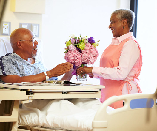 caretaker is bringing some flowers for her patient